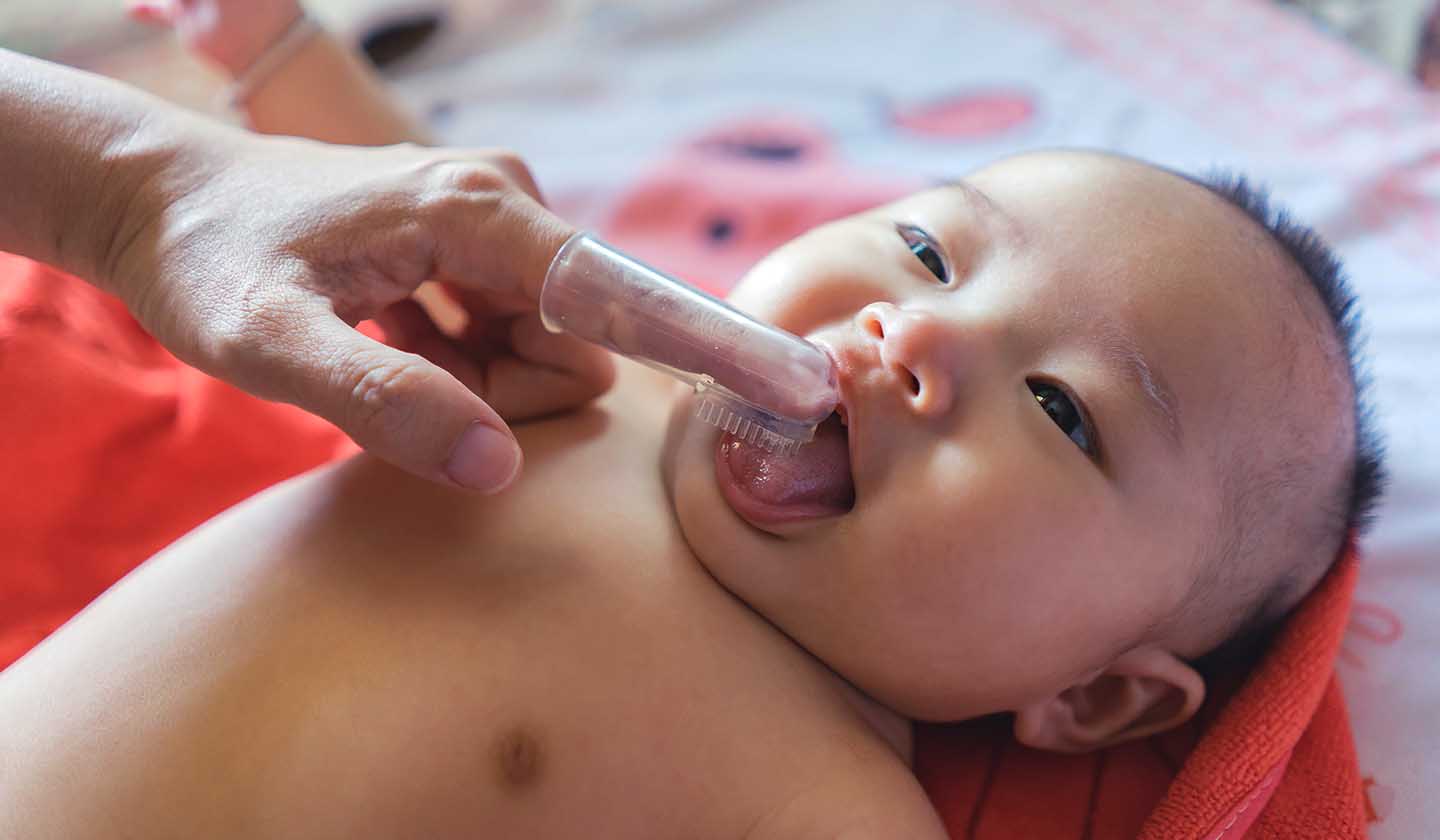 Massajar as gengivas com uma dedeira de silicone